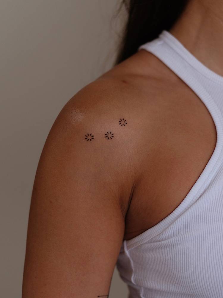 Minimalistic style flowers tattooed on the shoulder.