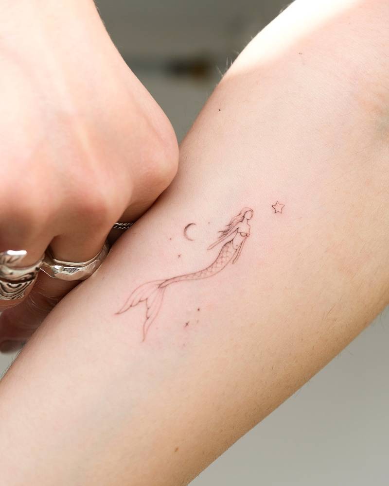 Single needle mermaid tattoo done on the inner arm.