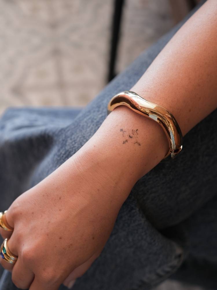 Minimalistic style ornamental design tattooed on the wrist.