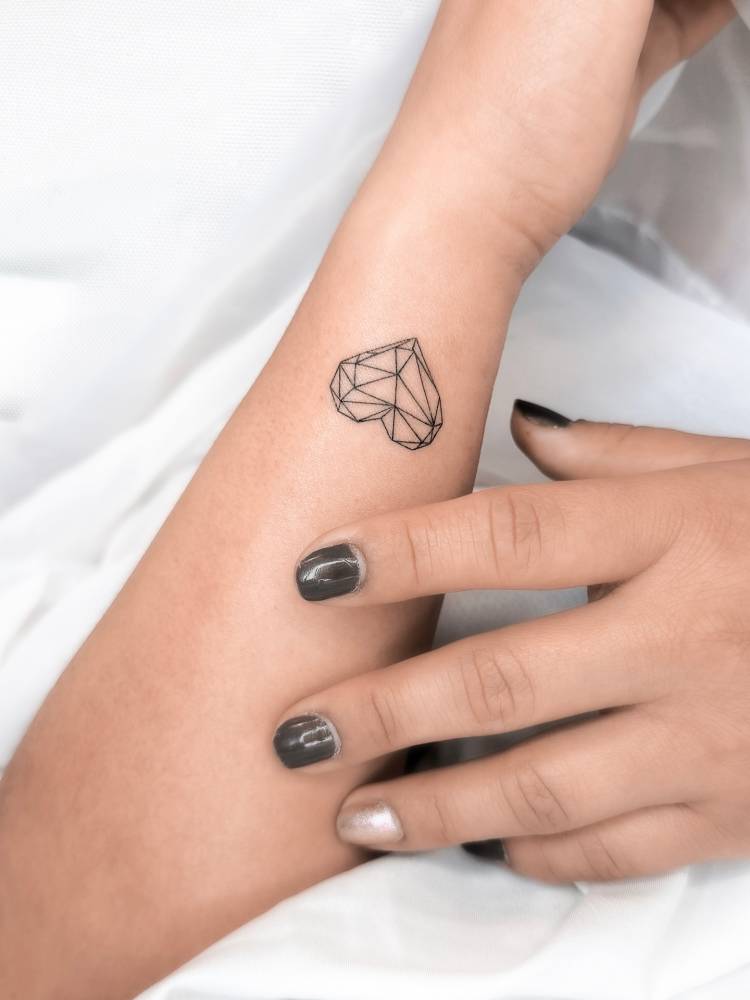 Low poly heart tattoo located on the wrist.