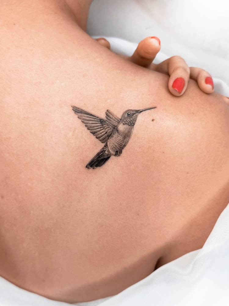 Hummingbird tattoo in micro-realistic style done on the shoulder blade.