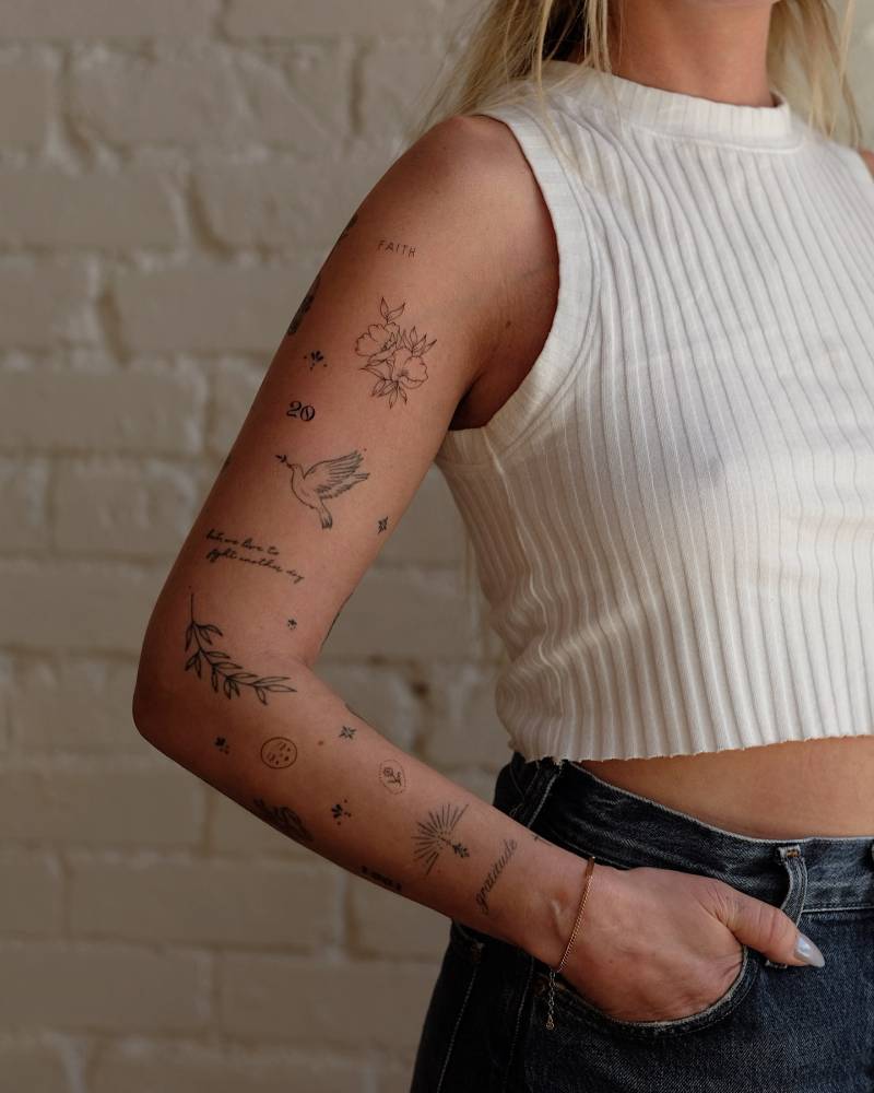 Fine line style arm composition tattoos.