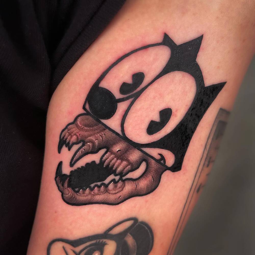 Pop art style Felix The Cat tattoo located on the upper arm.