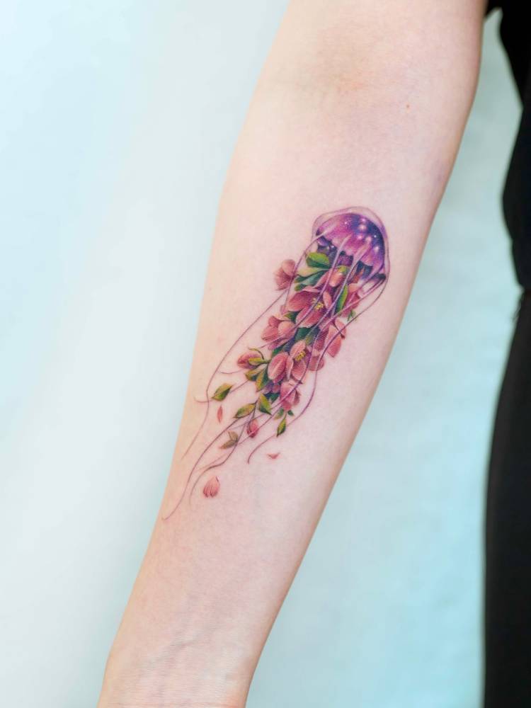 Watercolor style wisteria jellyfish tattoo located on the inner forearm.