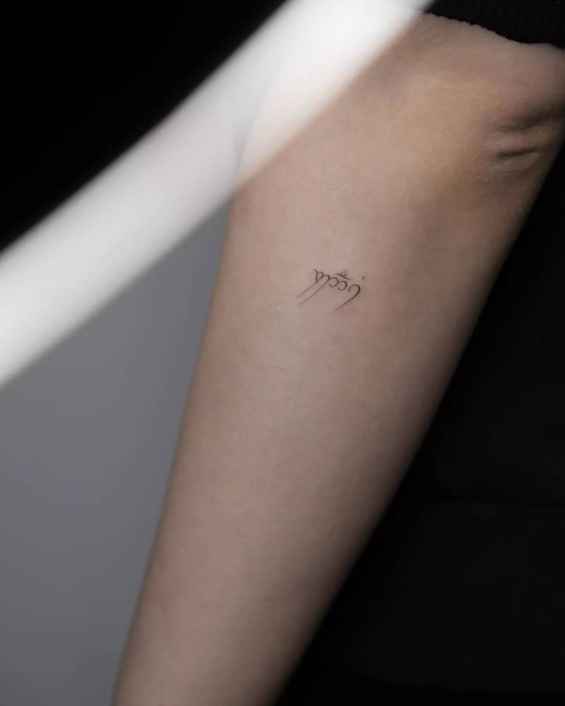 Elvish lettering tattoo located on the forearm.