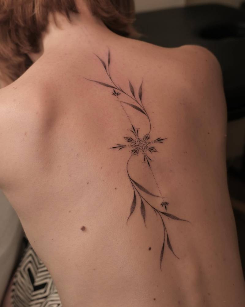 Hand poked leaves ornament tattooed on the back.