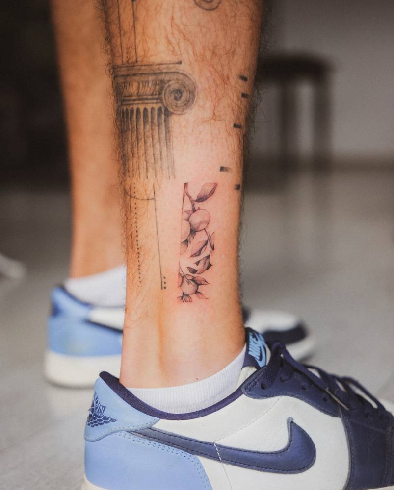 Blueberries tattoo in illustrative style located on the ankle.