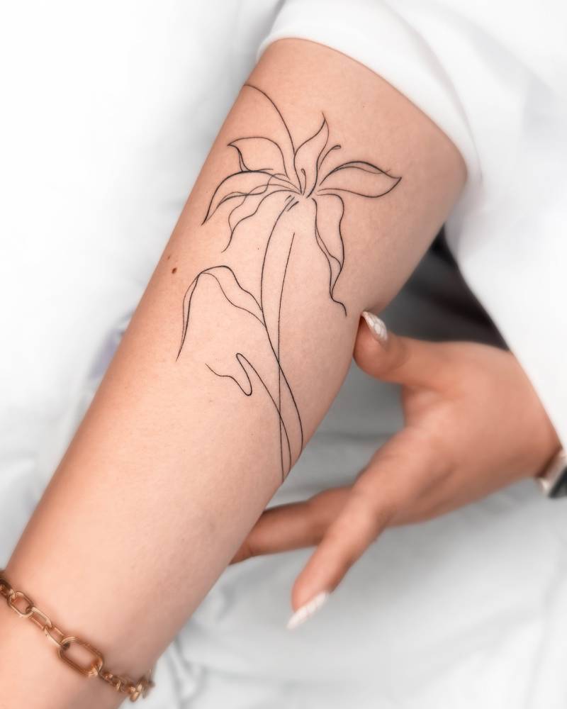 Line art style abstract lily flower tattoo located on the inner forearm.
