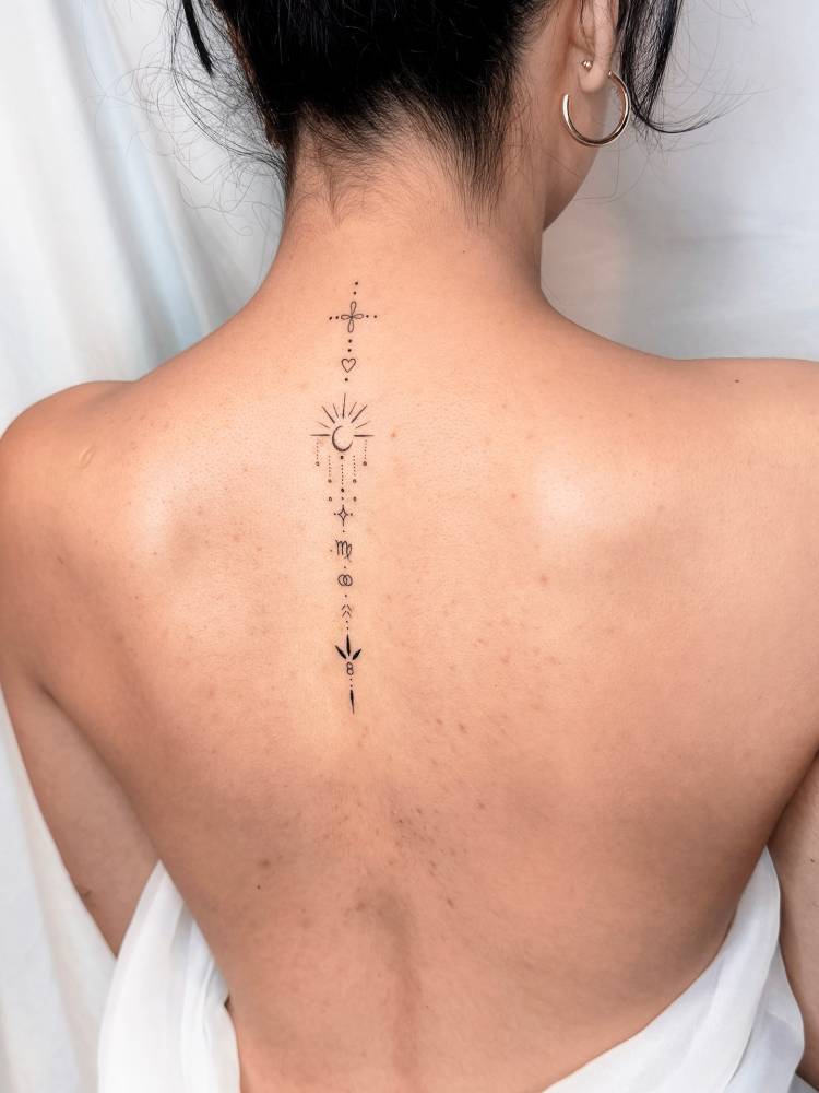 Symbol chain tattoo in fine line style located on the upper back.