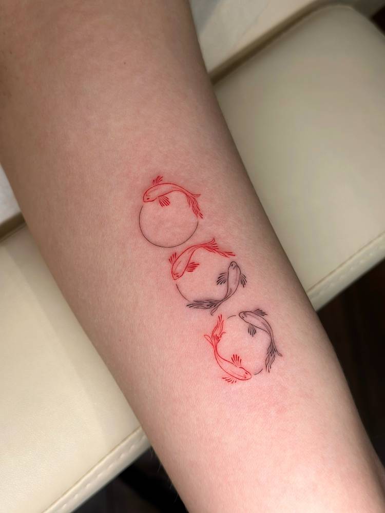 Fine line style two opposite fish sequence tattooed on the inner arm.