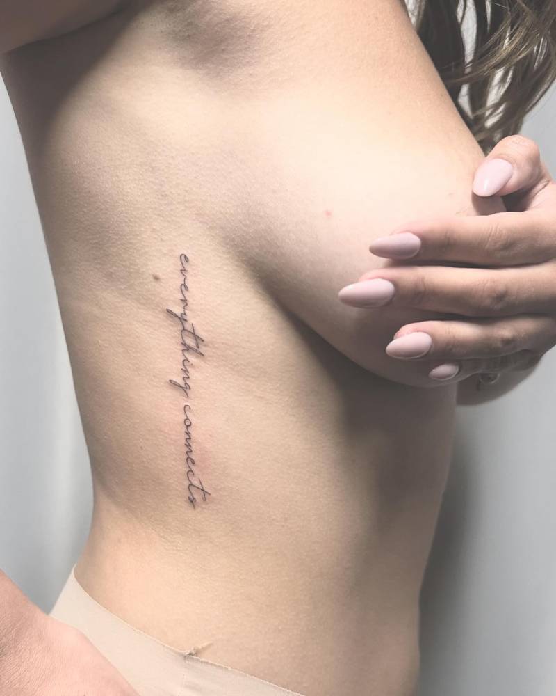 "Everything connects" lettering tattoo in handwritten font located on the rib.