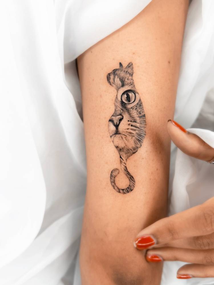 Cat portrait tattoo in micro-realistic style placed on the tricep.