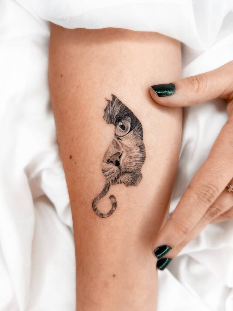 Cat portrait tattoo in micro-realistic style located on the inner forearm.
