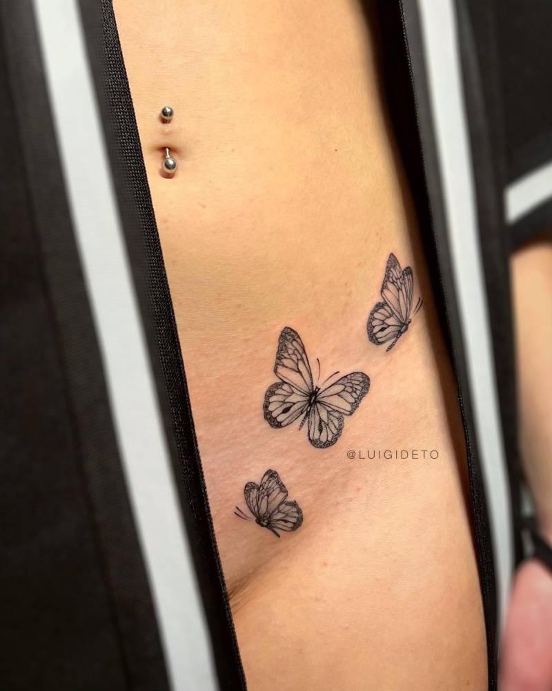 Butterfly collection tattooed on the pelvis, done in illustrative style.
