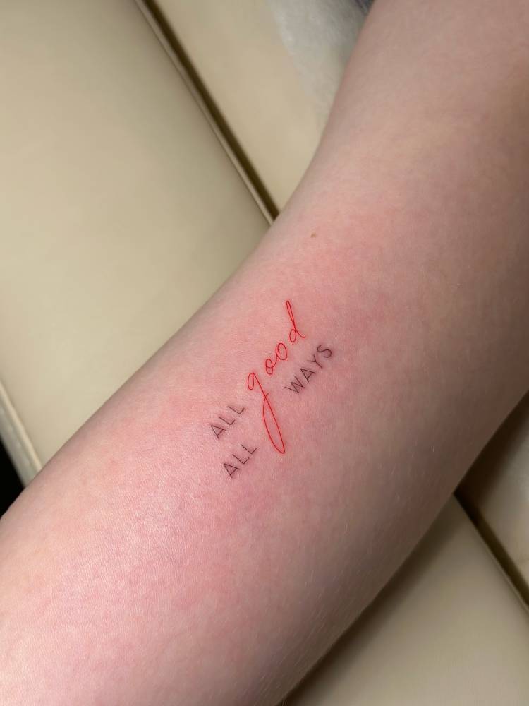 "All good, all ways" lettering tattoo located on the inner arm.