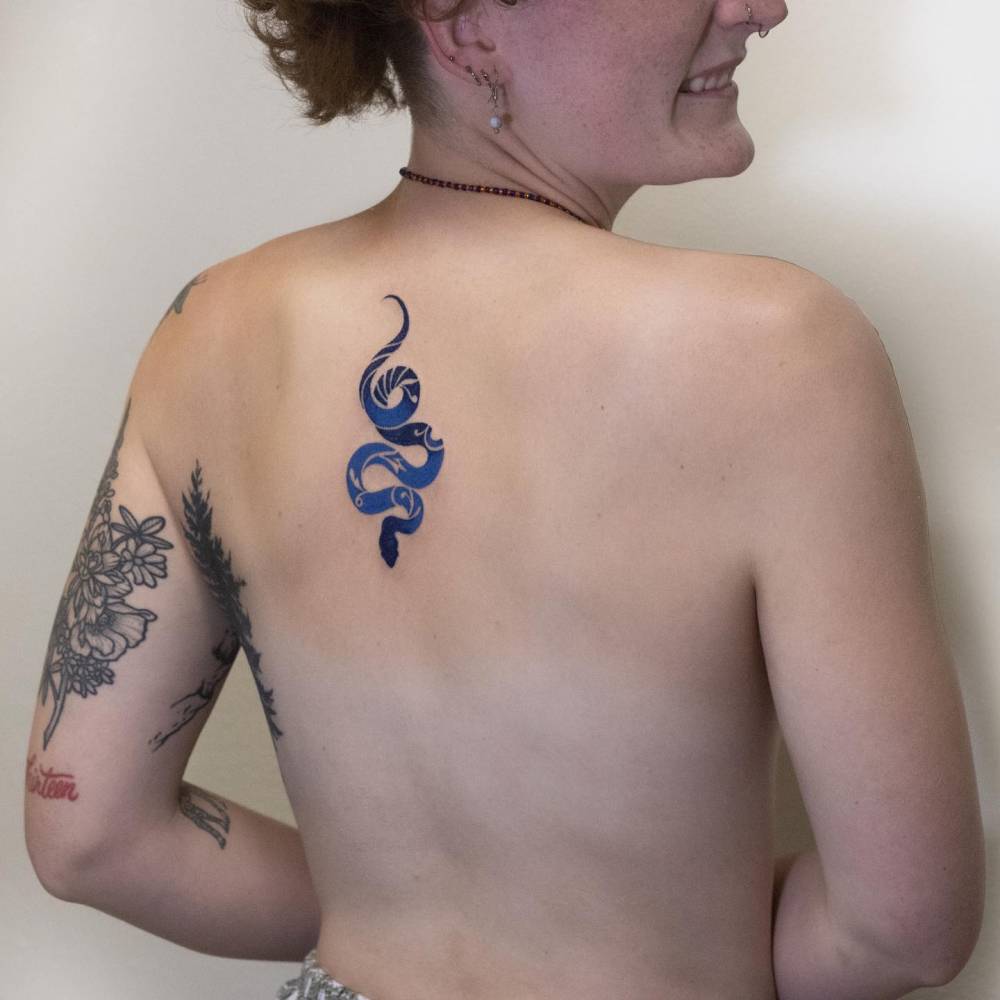 Blue snake tattoo located on the upper back, illustrative style.