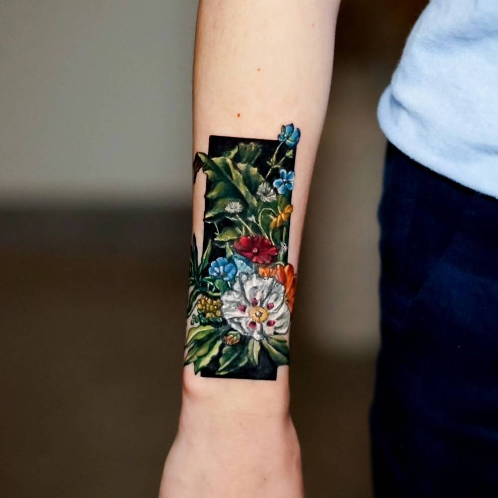 Watercolor style floral tattoo located on the wrist.