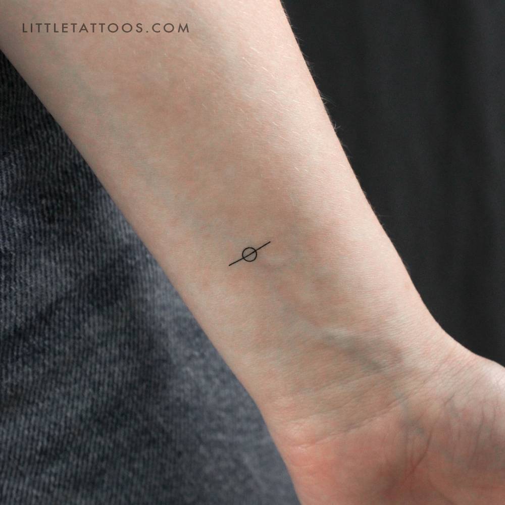 Minimalistic style Saturn temporary tattoo placed on the wrist.