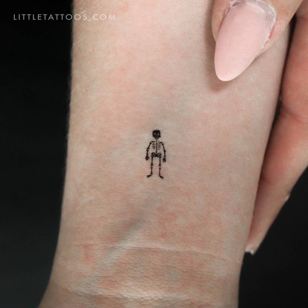 Tiny blackwork style skeleton temporary tattoo located on the wrist.