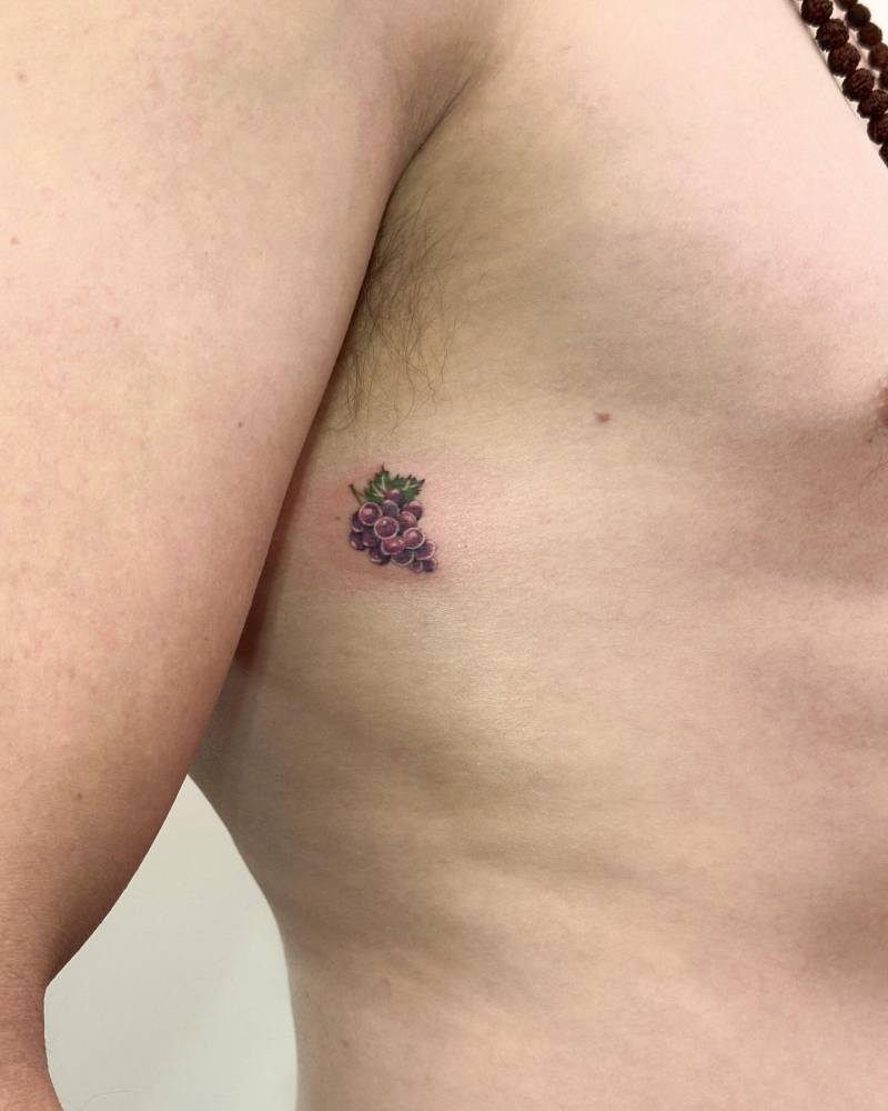 Illustrative style grapes tattoo placed on the rib.