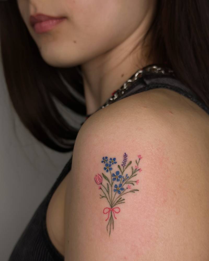 Watercolor style flower bouquet tattoo located on the shoulder.