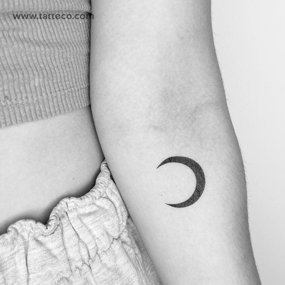 Black crescent temporary tattoo located on the inner forearm.