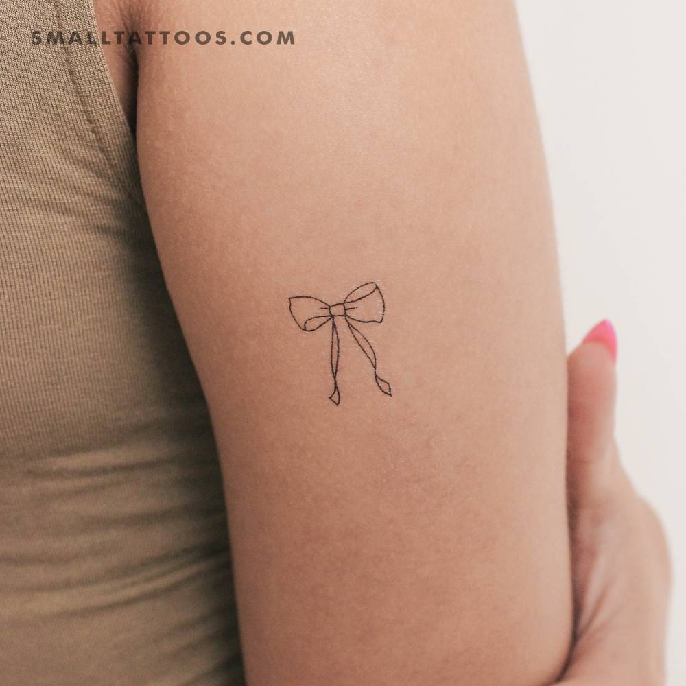 Fine line style bow temporary tattoo located on the tricep.