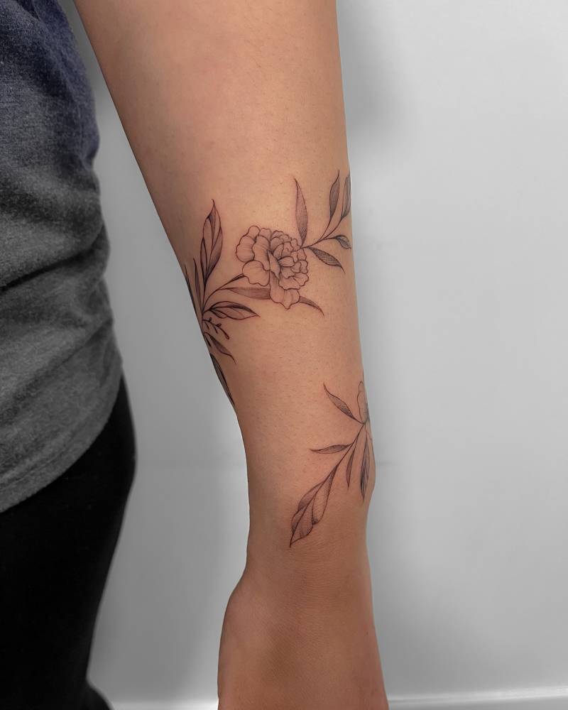 Flower bracelet tattoo in illustrative style located on the wrist.