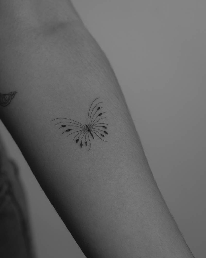 Single needle butterfly tattoo located on the inner forearm.