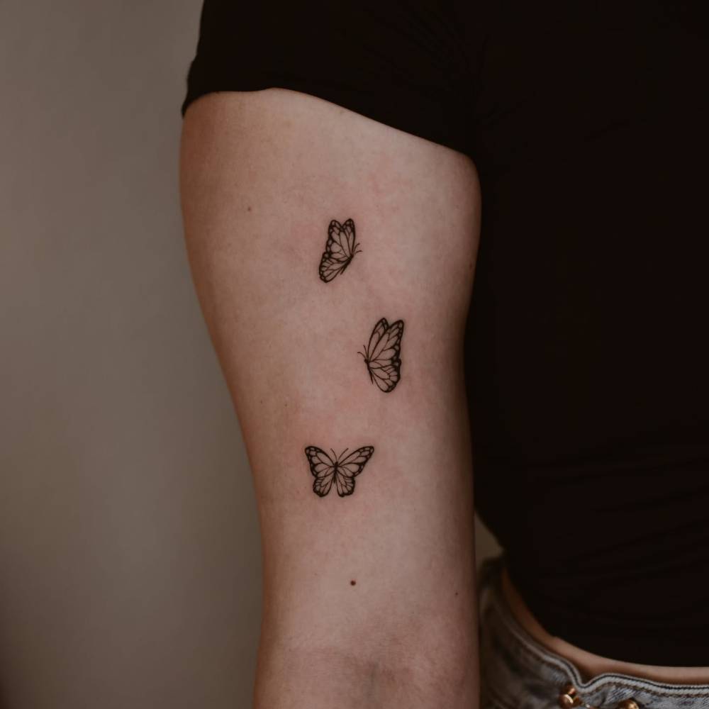 Butterflies tattoo in illustrative style located on the bicep.