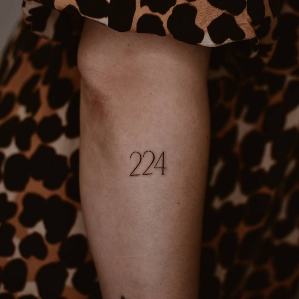 Number "224" tattoo located on the forearm.