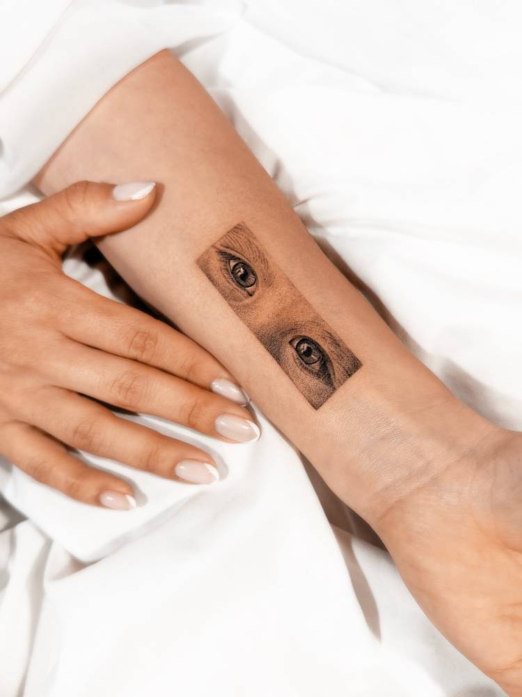 Eyes tattoo in micro-realistic style located on the wrist.