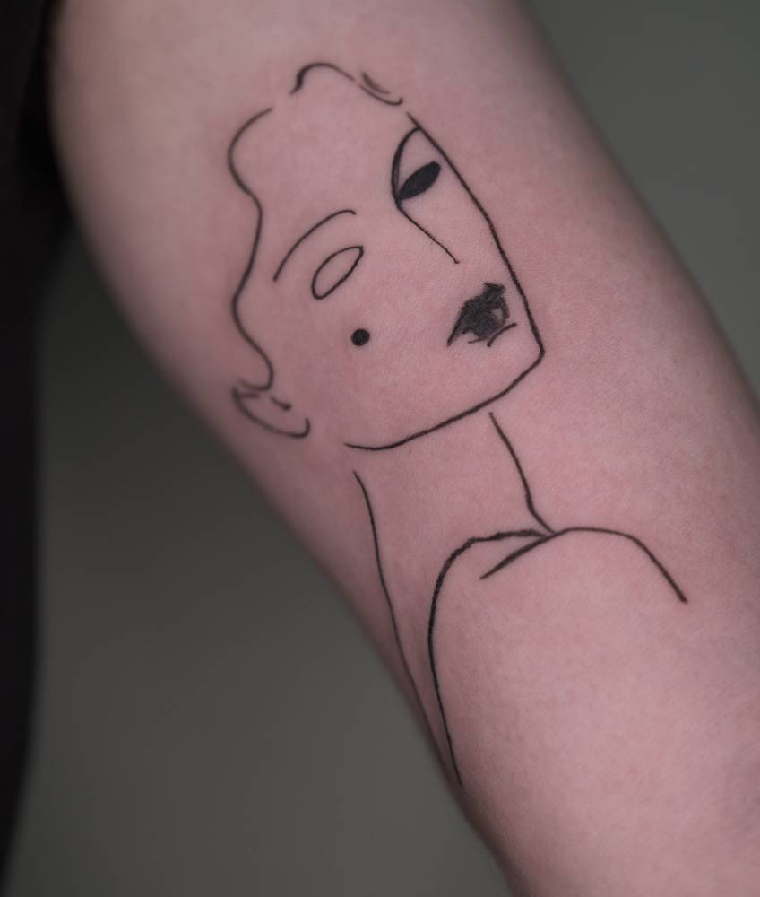 Sketch work style woman portrait tattoo located on the inner arm.