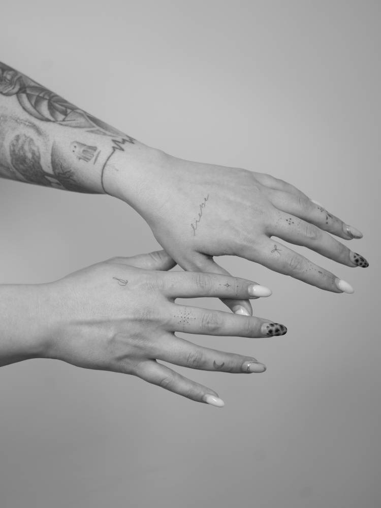 Ornamental finger composition tattoos in fine line style.