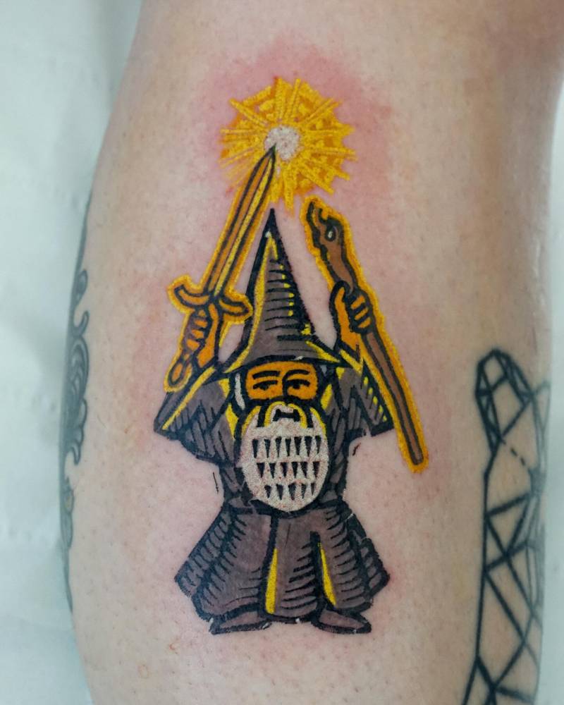 Pop art style Gandalf gnome tattoo located on the calf.