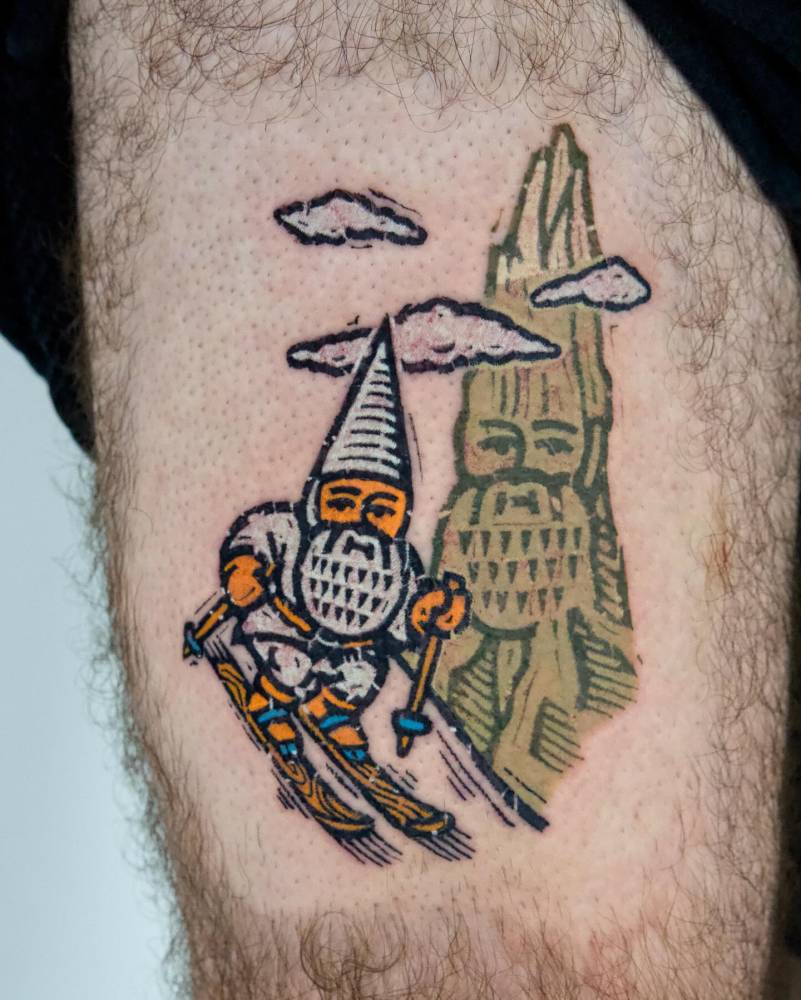 Skiing gnome tattoo placed on the thigh, pop art style.