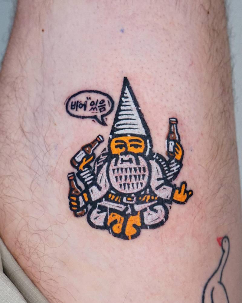 Cartoon style meditating gnome tattoo located on the thigh.