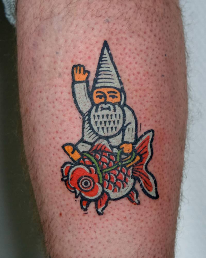 Gnome riding a goldfish tattooed on the calf, pop art style.