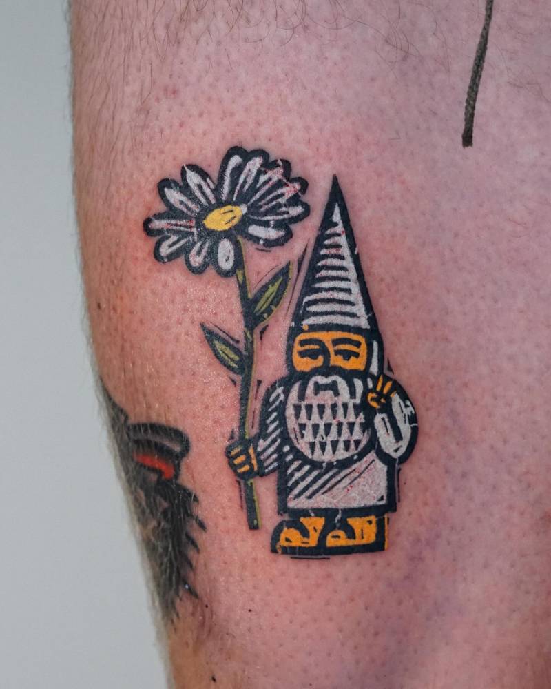 Gnome and daisy flower tattoo in pop art style located on the thigh.