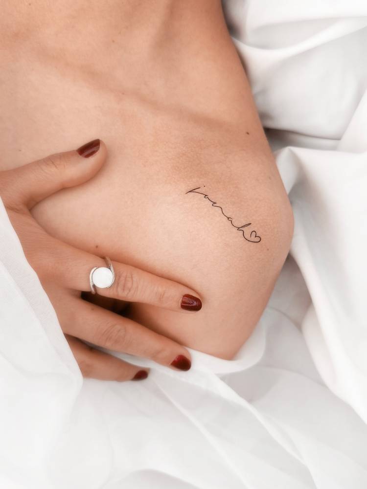 Lettering tattoo of the name "Jonah" located on the shoulder.