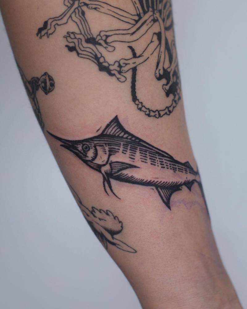 Engraving style swordfish tattoo located on the inner forearm.