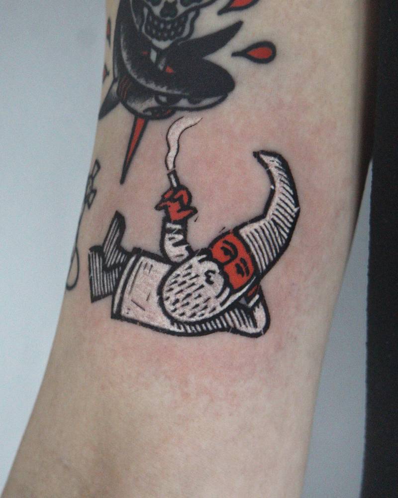Smoking gnome tattoo located on the bicep, pop art style.