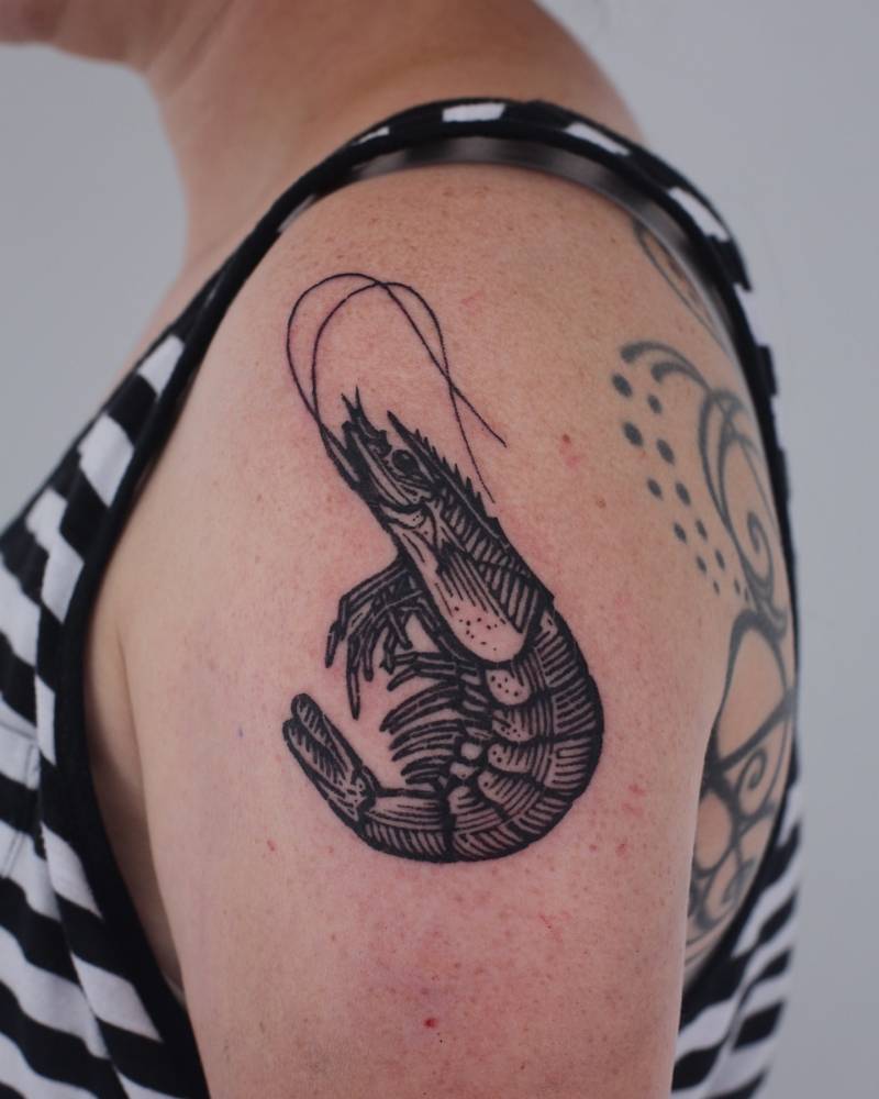 Shrimp tattoo in engraving style placed on the shoulder.