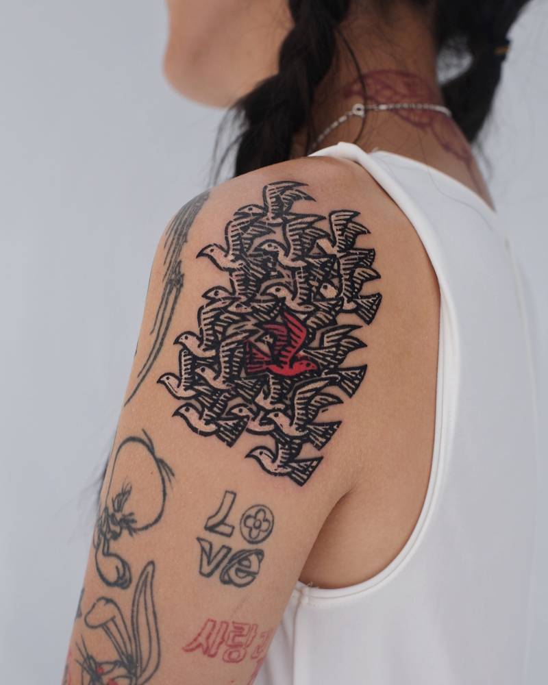 Pop art style doves tattoo placed on the shoulder.