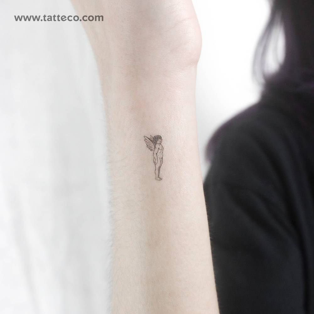 Tiny fine line cherub temporary tattoo located on the wrist.