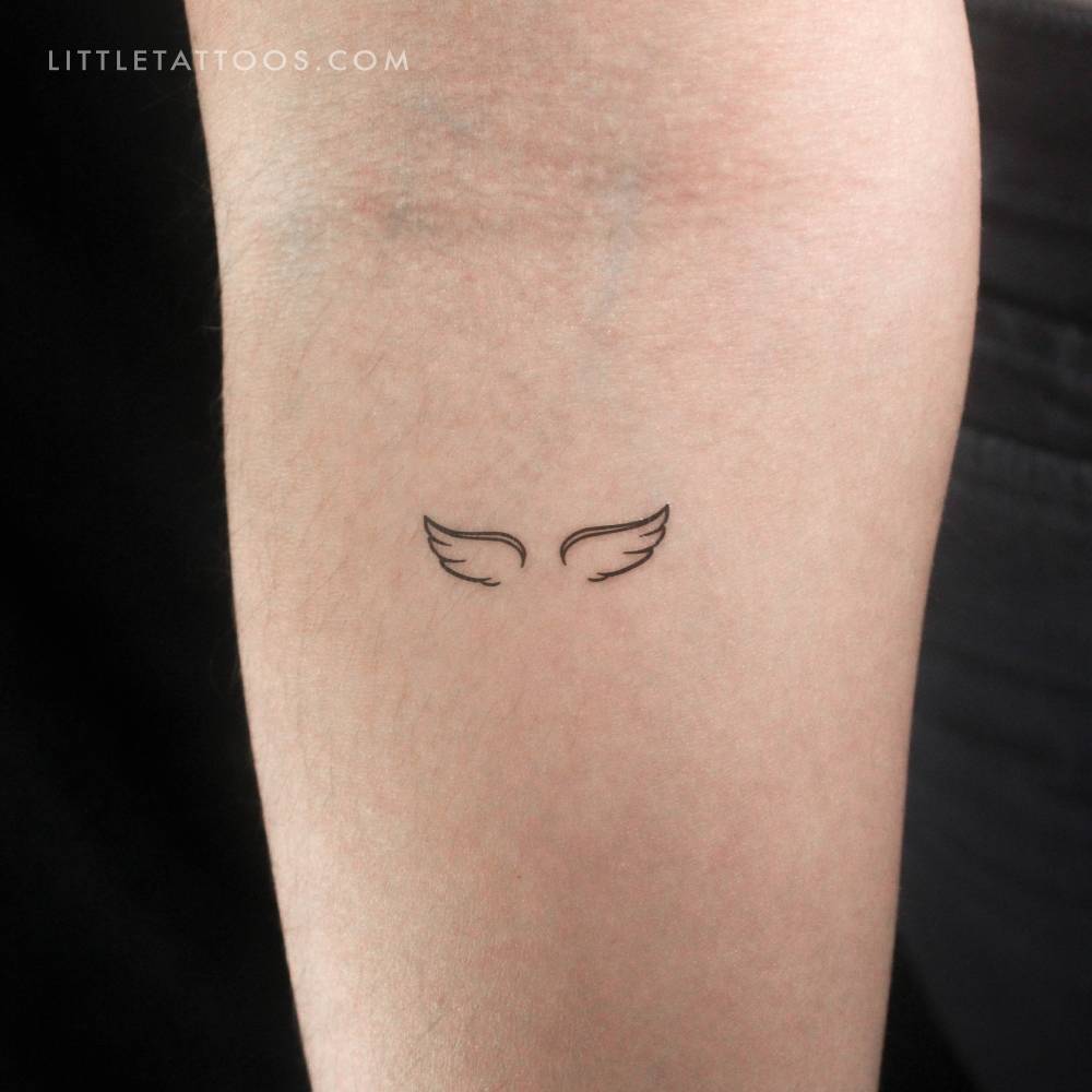Minimalistic style angel wings temporary tattoo located on the inner forearm.