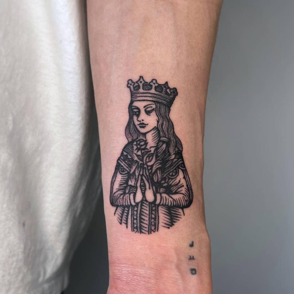 Queen tattoo in engraving style located on the wrist.