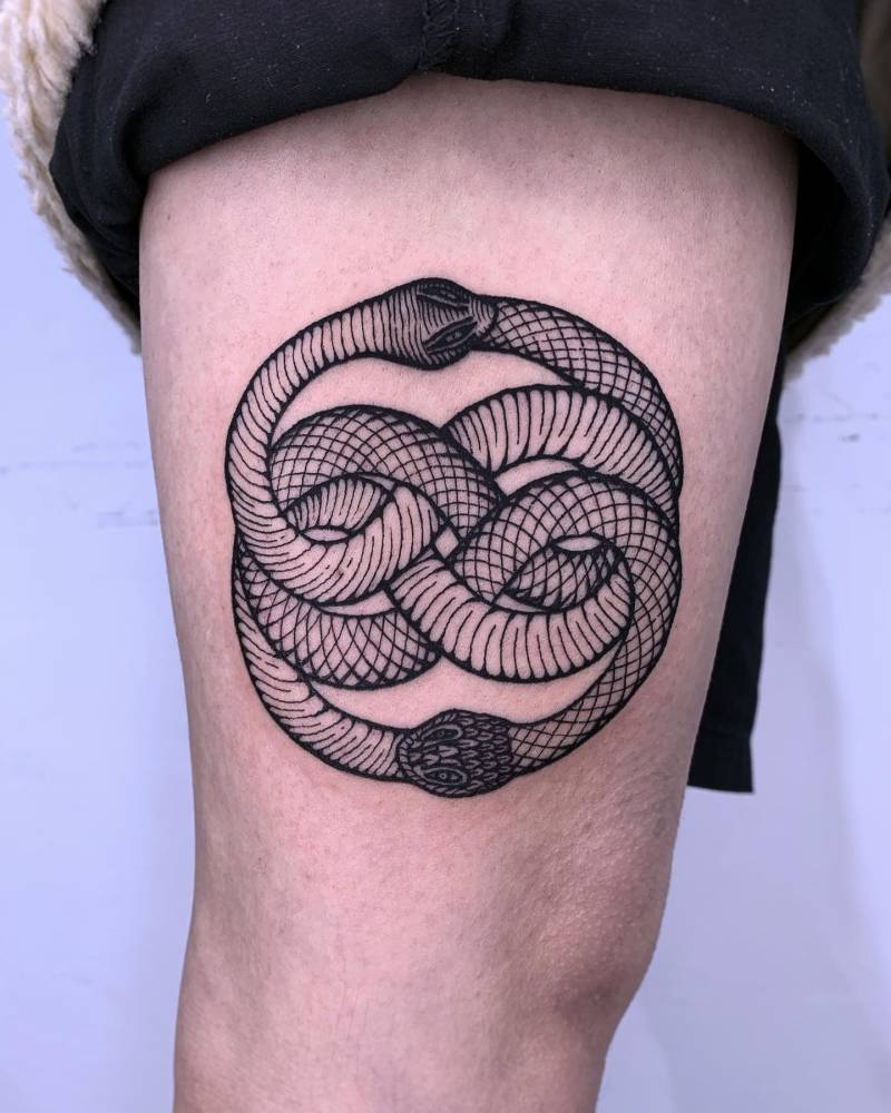 Snake ouroboros tattoo in blackwork style done on the thigh.