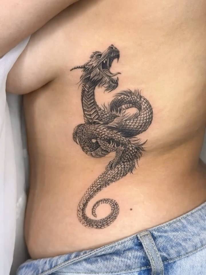 Micro-realistic style dragon tattoo placed on the rib.