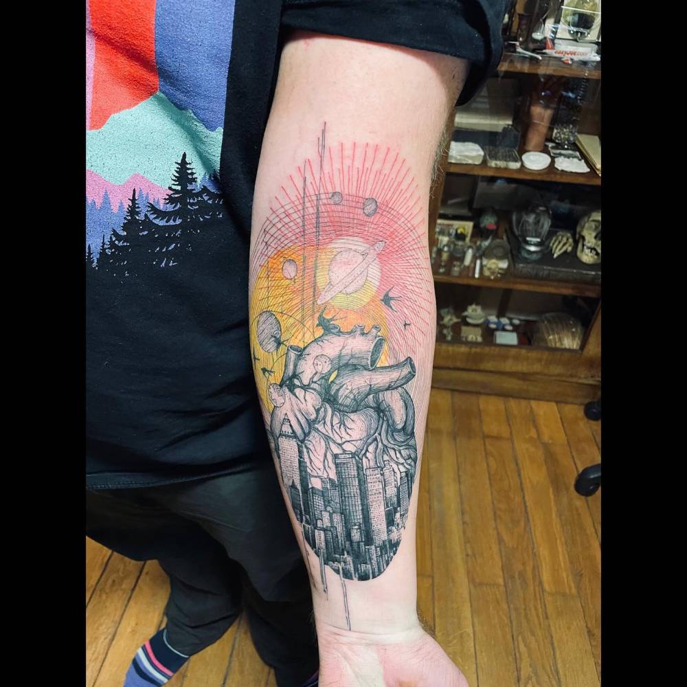 Graphic style anatomical heart and galaxy tattoo located on the inner forearm.
